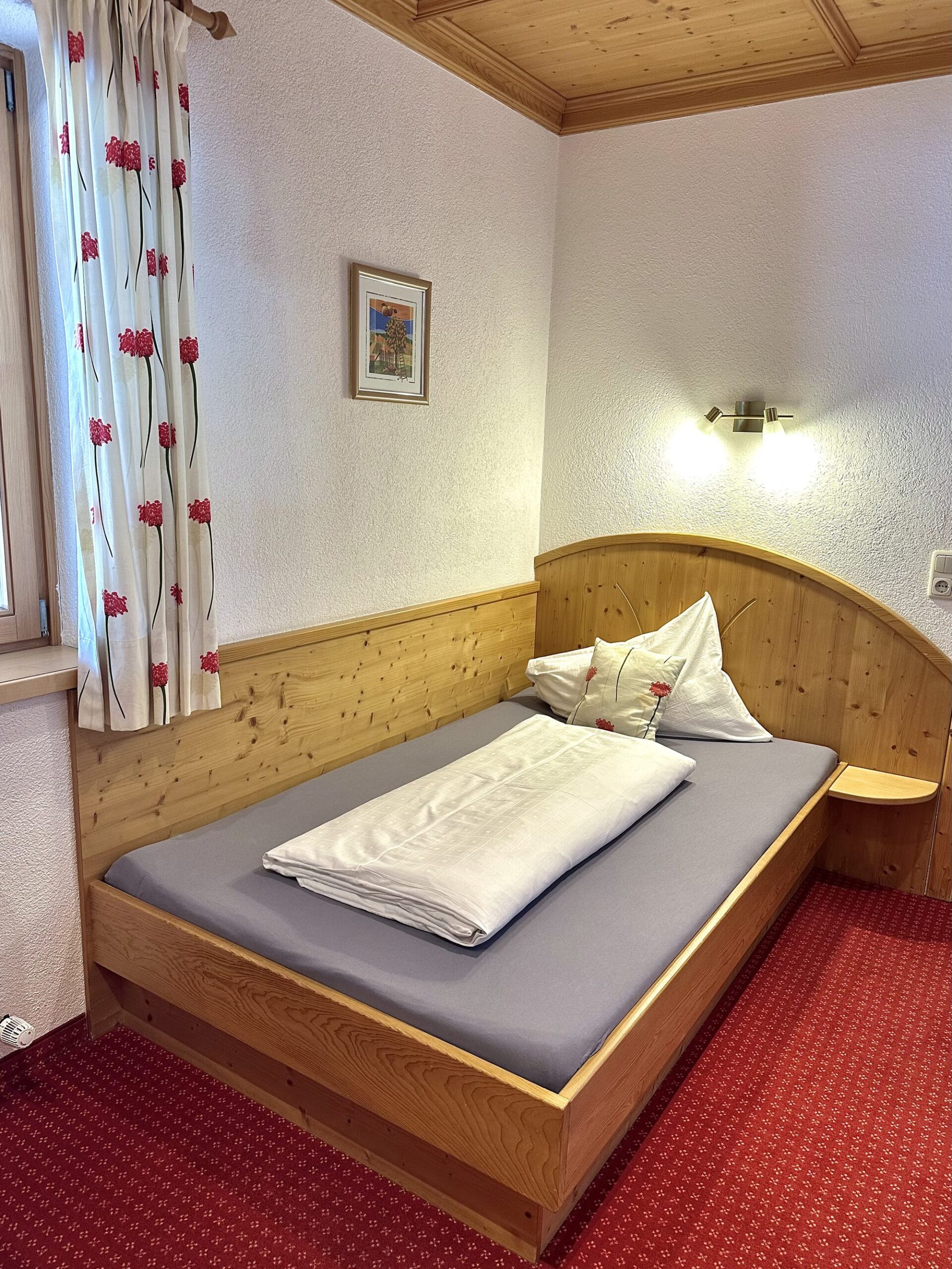 Einzelzimmer mit Holzbett im Landhaus Quehenberger in Maishofen