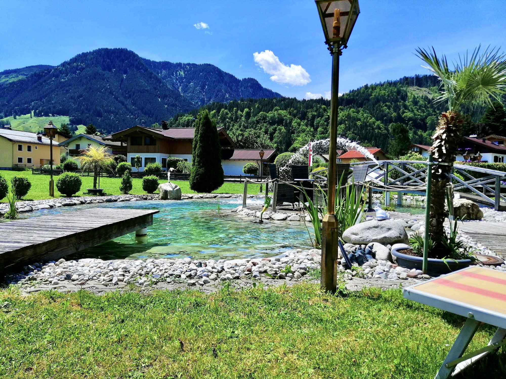 Naturteich mit Liegemöglichkeiten im Garten des Landhaus Quehenberger in Maishofen mit Bergblick