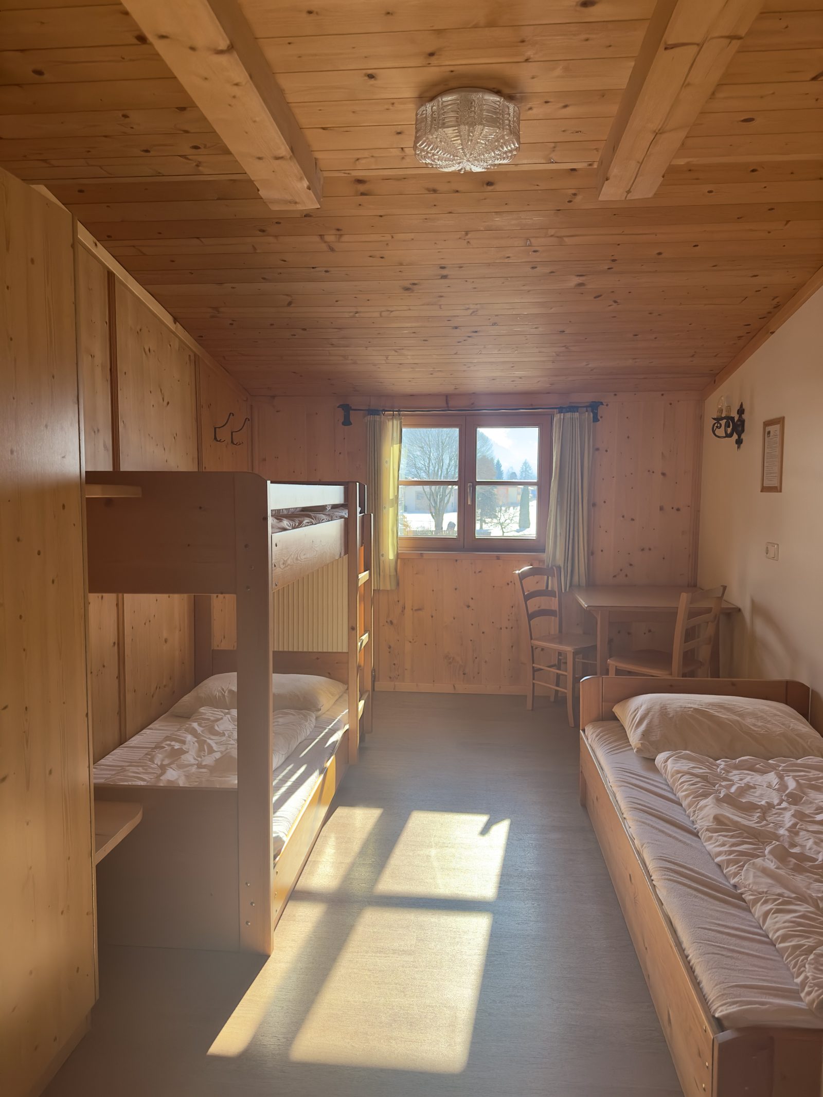 Heller Gruppenschlafraum mit Stockbett und Bergblick im Selbstversorgerhaus Maishofen im Salzburger Land