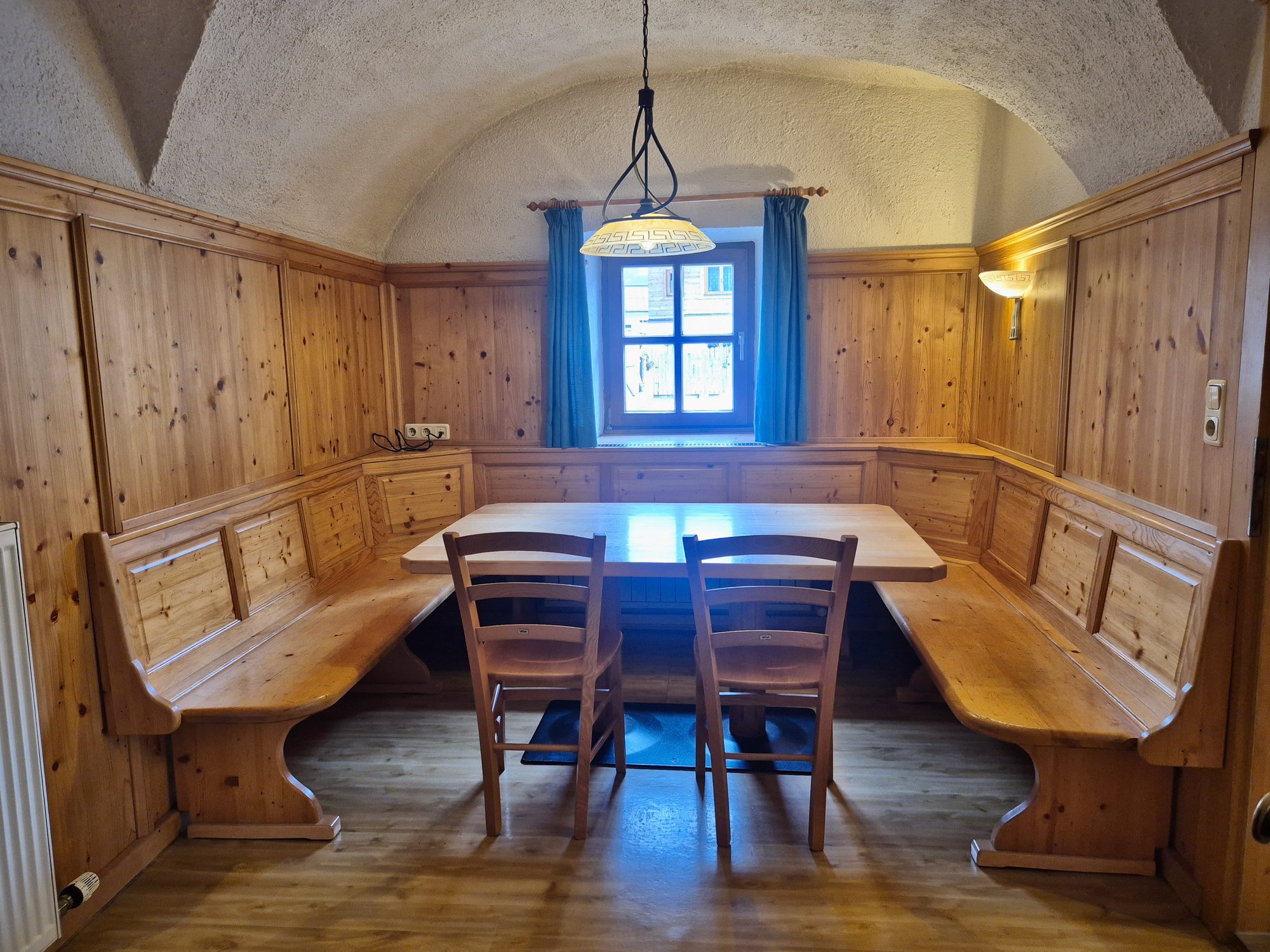 Gemütliches Holz-Stüberl im Selbstversorgerhaus Maishofen mit Eckbank und großem Holztisch.