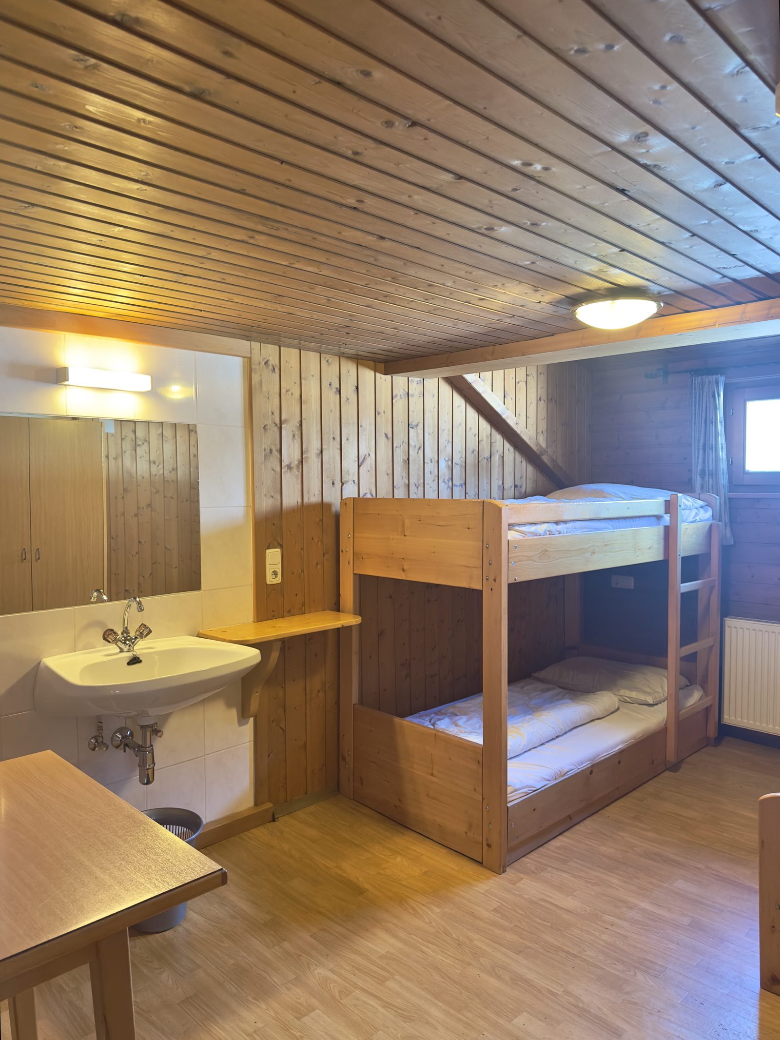 Mehrbettzimmer mit Stockbett und Waschbereich im Selbstversorgerhaus Maishofen