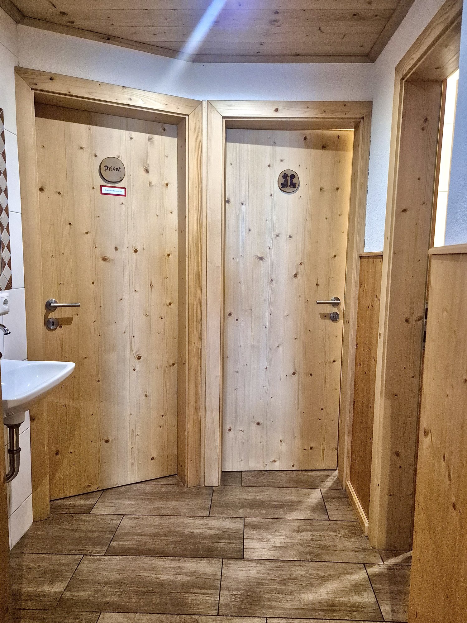 Sanitärbereich im Selbstversorgerhaus Maishofen mit modernen WC-Anlagen und Holzverkleidung