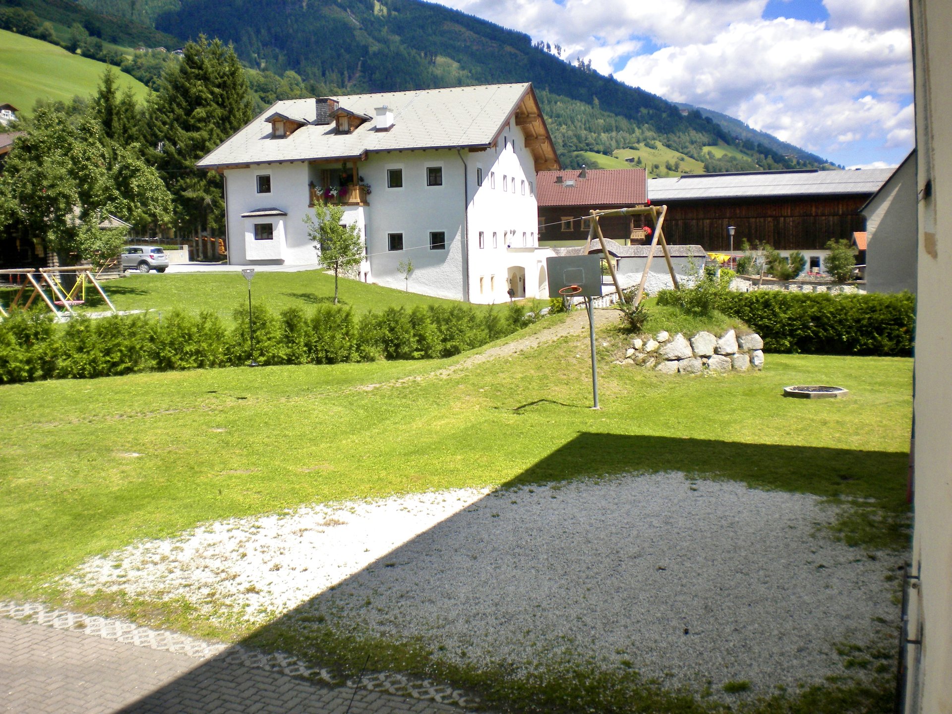 Gartenbereich des Selbstversorgerhaus Stuhlfelden mit Seilbahn, Spielwiese und Blick auf die Berge