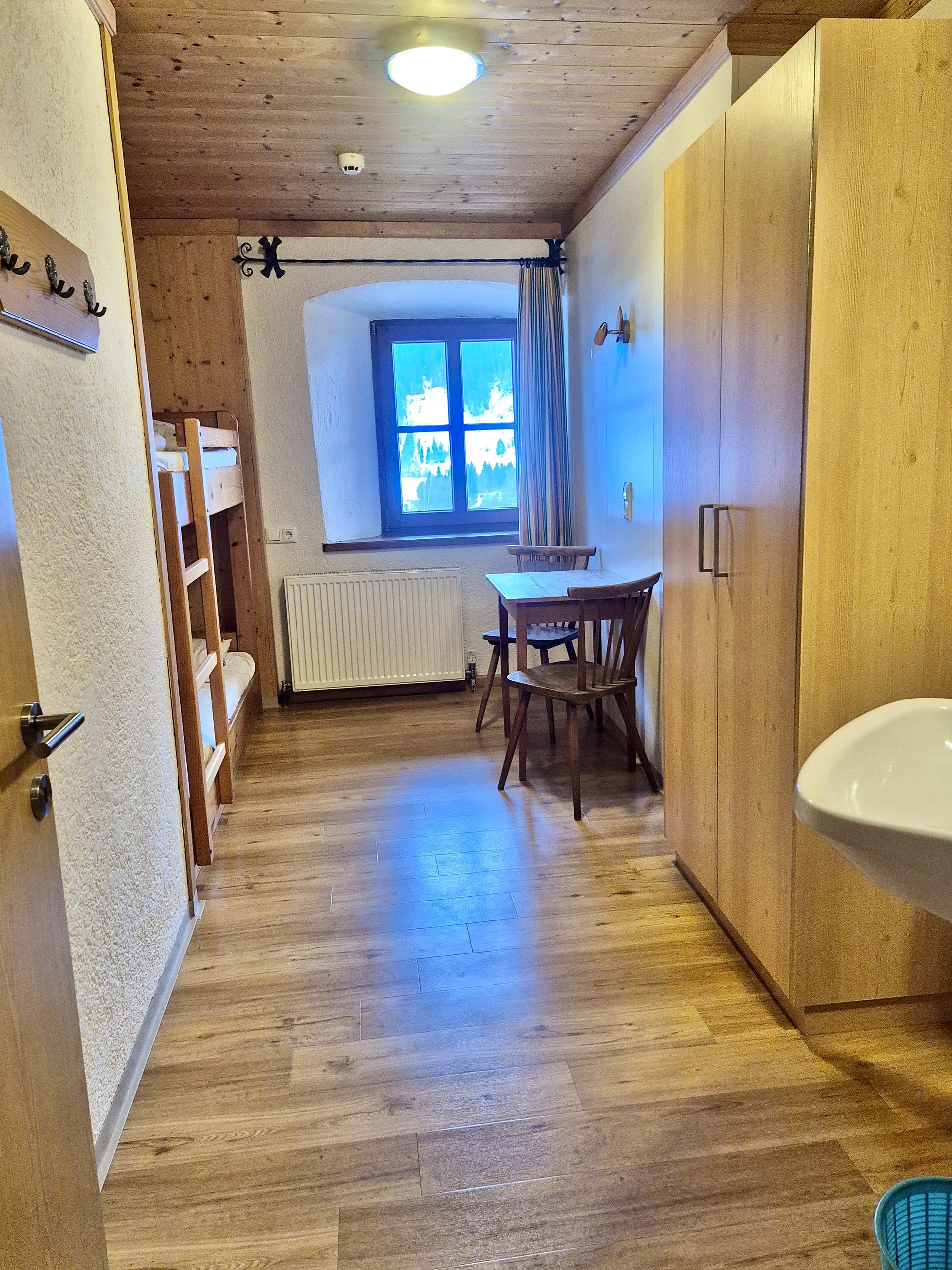 Zweibettzimmer mit Stockbett, Tisch und Waschbecken im Selbstversorgerhaus Stuhlfelden